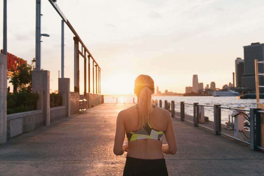 Young woman exercising outdoors,running along waterfront, rear view, Brooklyn, New York, USA